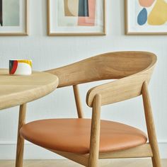 a wooden chair sitting in front of a table with a cup on top of it