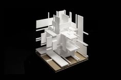 a model of a building made out of white paper on top of a black surface