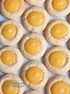 small cookies with yellow icing and black speckles on them are arranged in rows