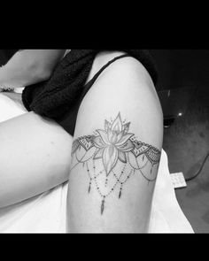 black and white photo of a woman's thigh with a flower tattoo on it