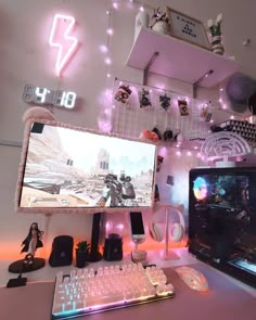 a computer desk with two monitors, keyboard and headphones on it in front of a pink light