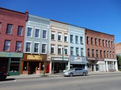 several buildings line the street with cars parked on the side walk in front of them