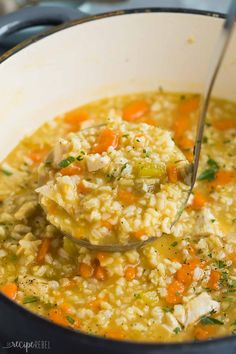 a ladle full of chicken and rice soup