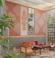 a living room filled with furniture next to a wall covered in art deco tiles and greenery