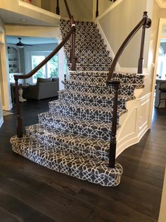 the stairs are decorated with black and white designs on them, along with wood flooring