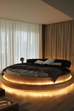 a circular bed with lights around it in the middle of a wooden floored room