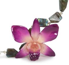 a purple flower is surrounded by crystals and beads