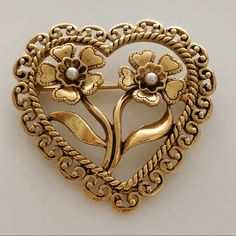 Avon Large Heart Flower Pearl Pin Brooch Vintage Antiqued Gold Tone Decorative Detail Metal Finish Center Long Stems Petals Seed Beads Leaves With Open Scroll Edge. Gorgeous, Cute, Chic, Fashion Jewelry! Versatile To Wear At The Office, Career Wear Or Dress Up For A Wedding Or Night Out. Collectible Jewelry. See Pics # 12-13, For Approximate Measurements. Measures 1 1/2 Inches Long By 1 1/2 Inches Long. Condition: In Great Never Worn Still In The Original Box Vintage Condition. Please Note: Has Plush Oc, Vintage Brooch For Valentine's Day Formal, Vintage Heart Brooch, Avon Jewelry Vintage Originals, Vintage Avon Jewelry, Avon Pins With Perfume, Vintage Gold-tone Brooches For Formal Occasions, Rare Pearls Avon, Avon Vintage