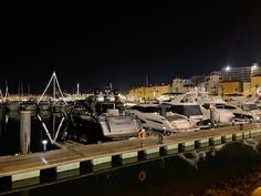 several boats are docked in the marina at night