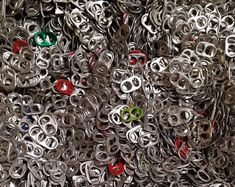 a pile of silver metal rings with red and green eyes