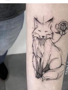 a black and white photo of a fox with a rose tattoo on the arm,