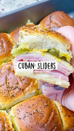 someone holding a ham and cheese slider in their left hand with the words cuban sliders on it