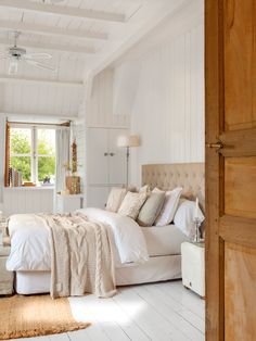 a bedroom with white walls and wooden floors