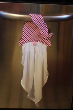 a red and white striped towel hanging on a stainless steel dishwasher door handle