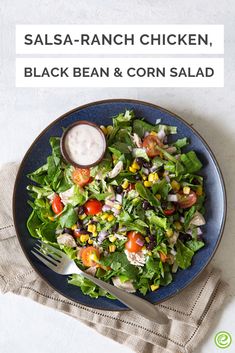 a salad with black bean and corn is on a blue plate next to a fork