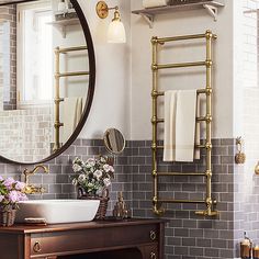 a bathroom with a sink, mirror and towel rack on the wall in front of it