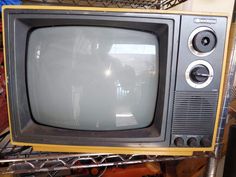 an old television sitting on top of a metal rack