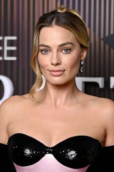 a woman in a black and pink dress posing for the camera with her eyes wide open