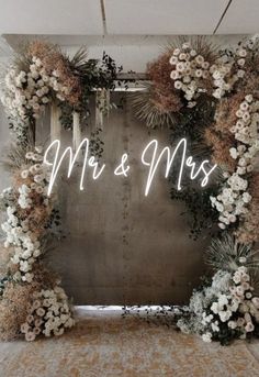 a sign that says mr and mrs with flowers in front of the letters on it