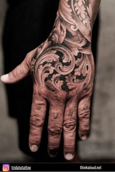 a person's hand with tattoos on it and an intricate design in the middle