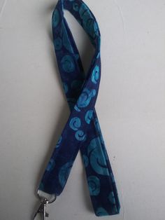 "Blue and dark blue lanyard. This listing is for ONE lanyard! Handmade by me with 100% cotton fabric measuring approximately 40-42 inches around(20\"-21\" Drop when placed around neck) and 3/4 inch wide. A key ring and a swivel clasp/hook are attached to the lanyard. Lanyards can be used for functional purposes such as I.D. wearing and attaching to keys for easy around-the-neck-wearing. This one would make an awesome gift. Hand washing recommended for lanyard, lay flat to dry. Thank You for shop Badge Lanyard, Seat Belt Cover, Watercolor Pattern, Id Badge, Badge Holders Lanyard, Lanyard, Green And Brown, Key Rings, Color Matching