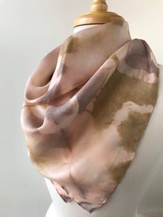 a white mannequin wearing a pink and brown scarf