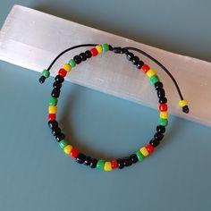 Rasta Seed Beads Bracelet, Adjustable Jamaican Bob Marley Style, Reggae Red, Yellow, Green, Black | Unisex Gift | Rastafari Vibes, One Love, Handmade Gift for Her & Him Rasta Bracelet - Radiate the Reggae Spirit! Handmade with a celebration of Rastafari Seed Beads in Jamaican Bob Marley Style. Capturing the Red, Yellow, Green, and Black essence of Reggae, this unisex bracelet is a unique gift for all. Handcrafted Details: Authentic Rastafari Design: Representing unity, love and positivity resona Jamaican Bracelets, Jamaican Crafts, Reggae Bracelet, Jamaica Bob Marley, Rasta Wedding, Rasta Bracelet, Rasta Style, Adjustable Beaded Bracelet, Style Bob