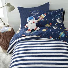 a child's bed with an astronaut themed comforter and matching pillowcases