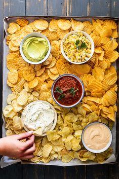 a tray filled with chips and salsa dips