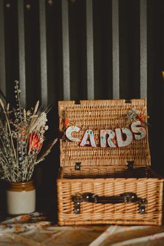 two wicker baskets sitting next to each other on top of a wooden table with flowers