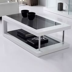 a white coffee table with two black cups on it