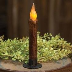 a lit candle sitting on top of a potted plant