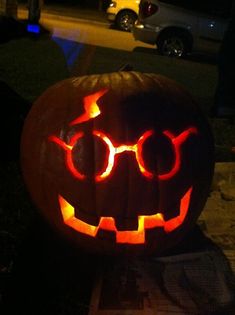 a pumpkin with glasses carved into it's face and glowing eyes on the outside