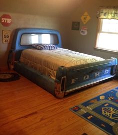 a bedroom with a bed made out of an old truck bed and rugs on the floor