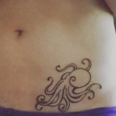 a woman's stomach with an octopus tattoo on it