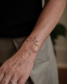 a person with a tattoo on their arm holding onto a white object in front of them