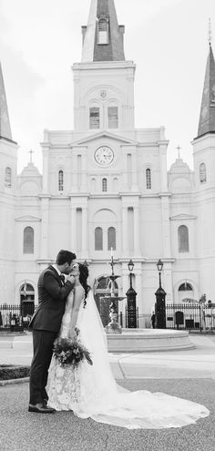 a bride and groom kissing in front of a church