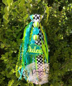 an ornament hanging from a tree in the shape of a bottle with bubbles on it