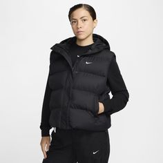 Up your outerwear game in this puffer vest. A loose fit makes it ideal for layering while the Nike Therma-FIT technology helps manage your body’s natural heat to help keep you warm in cold-weather conditions. A water-repellent finish, bungees at the hem and a hood work together to help shield you from wind and rain. Nike Bodywarmer, Nike Puffer, Wind And Rain, Hooded Vest, Ripstop Fabric, Women Lifestyle, Wet Weather, Black White Fashion, Working Together