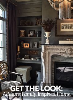 a living room filled with furniture and a fire place under a chandelier hanging from the ceiling