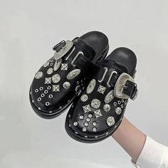 Unleash your punk style with our Black Gothic Punk Studded Clogs! Crafted from premium faux leather, these clogs boast a round toe and adjustable metal pin-buckle strap for a comfy fit. Slip them on easily to rock the eyelet vents and studded details that bring an edgy flair to any look. Ideal for fashion-forward women aiming to stand out. Premium faux leather Round toe Adjustable metal pin-buckle strap Eyelet vents Studded details Easy to slip on Trendy Clogs With Buckle Closure, Trendy Mules With Buckle Closure And Round Toe, Trendy Round Toe Mules With Buckle Closure, Trendy Closed Toe Clogs With Buckle Closure, Trendy Closed Toe Clogs With Buckle, Black Studded Mules With Round Toe, Trendy Clogs With Buckle Closure And Round Toe, Trendy Streetwear Clogs With Round Toe, Trendy Round Toe Clogs For Streetwear