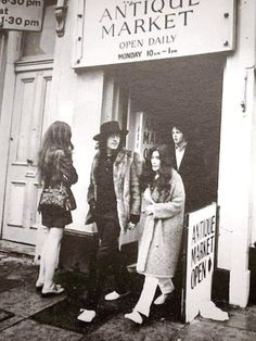 an old black and white photo of people standing in front of the antique market store