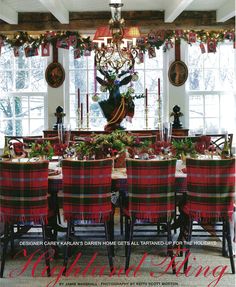 a dining room table with plaid chairs and christmas decorations on the windowsills above it