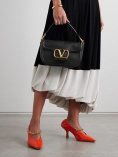 Timeless and classic, Valentino Garavani's 'VLOGO' bag is one that you'll love for years to come. Crafted from black textured-leather, it's centered with the maison's gold-tone logo that's subtly burnished for an antique finish. It's perfectly sized to fit your phone, cardholder, earbuds and keys. Formal Double Handle Bag With Logo, Leather Evening Bag With Logo, Evening Leather Bags With Logo, Evening Leather Bag With Logo, Luxury Shoulder Bag With Logo And Double Handle, Top Handle Shoulder Bag With Logo For Evening, Luxury Shoulder Bag With Double Handle And Logo, Elegant Leather Bags With Logo, Formal Double Handle Shoulder Bag With Logo