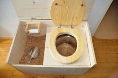 a wooden toilet seat with the lid up in a small bathroom area that is made out of wood planks