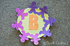 a paper plate with the letter b on it sitting on top of carpeted floor