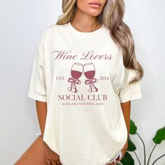 a woman wearing a wine lover's social club t - shirt with two glasses on it