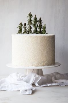 a cake with white frosting and green sprigs sitting on top of it