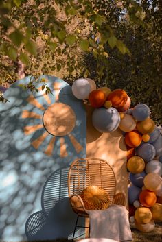 an outdoor area with balloons and chairs in the shade, along with a large sun - shaped wall