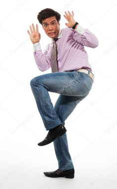 a young man in jeans and a pink shirt is dancing with his hands up to the side